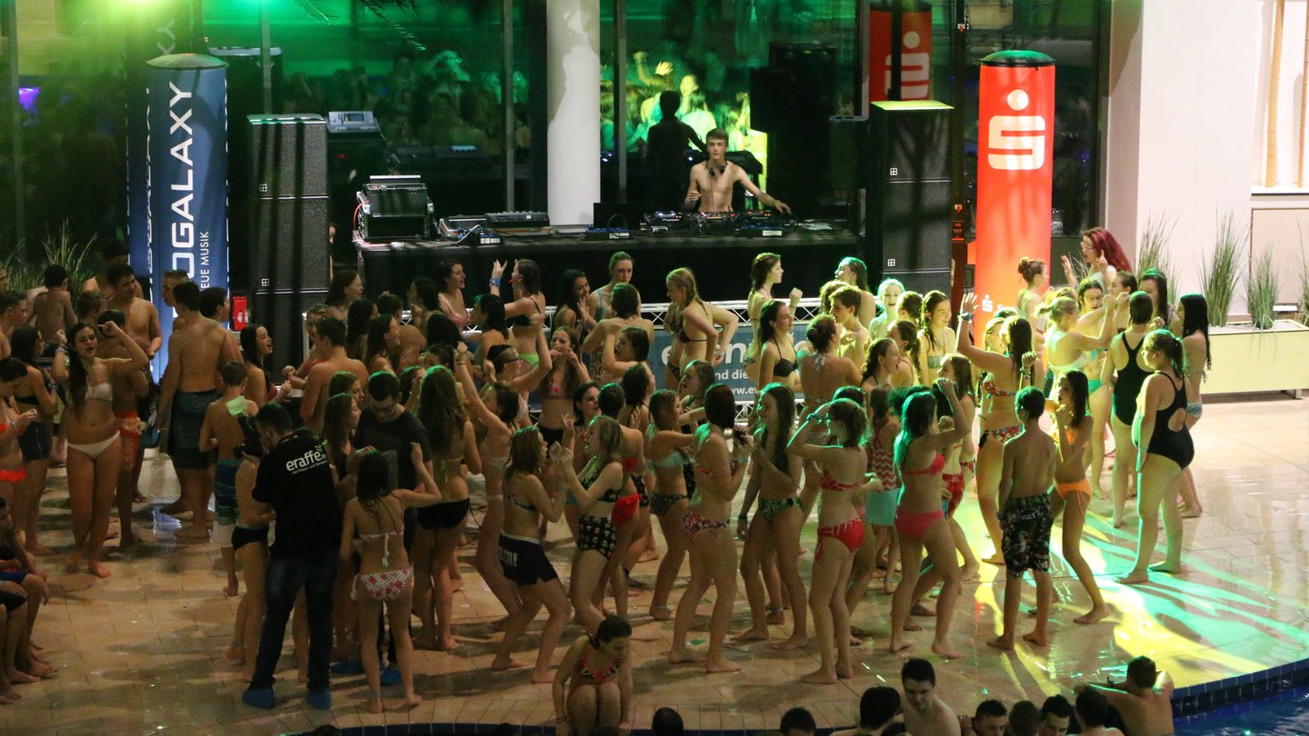 DJ beim Poolparty mit tanzen Gästen im Bambados