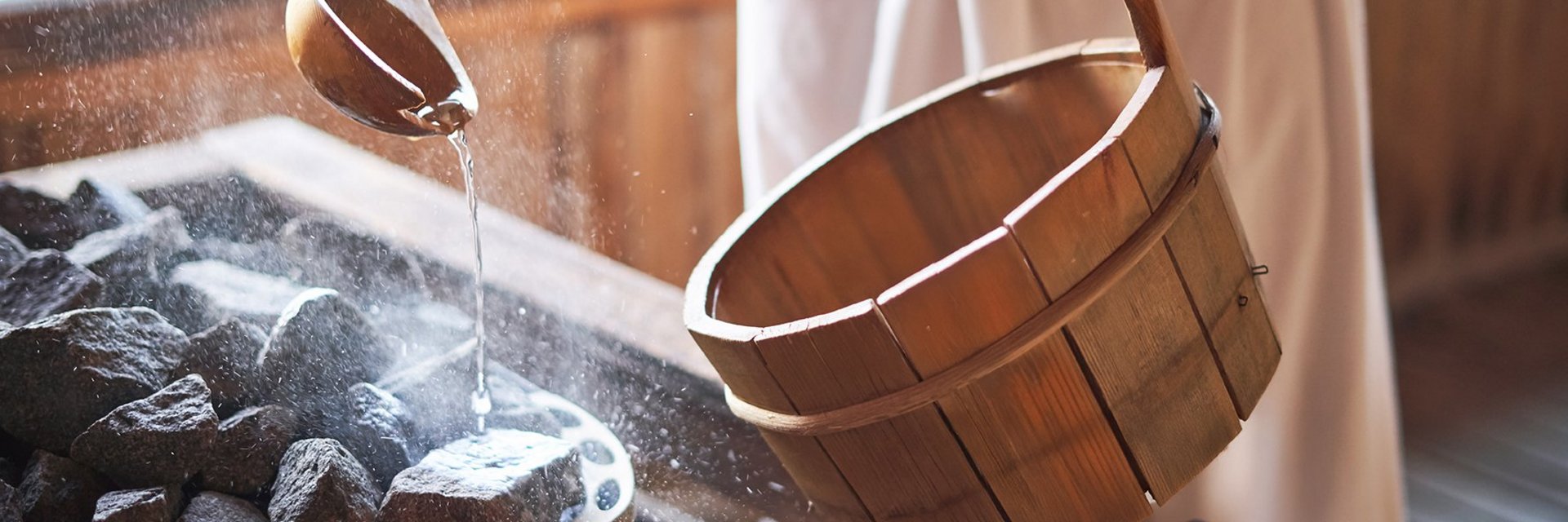 Holzeimer und Holzkelle in einer Sauna beim Aufguss